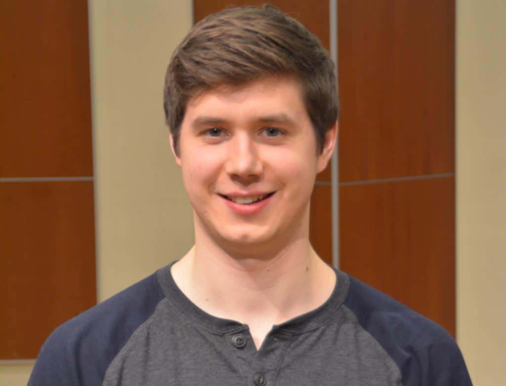 A headshot of Jacob Mezera standing on a stage