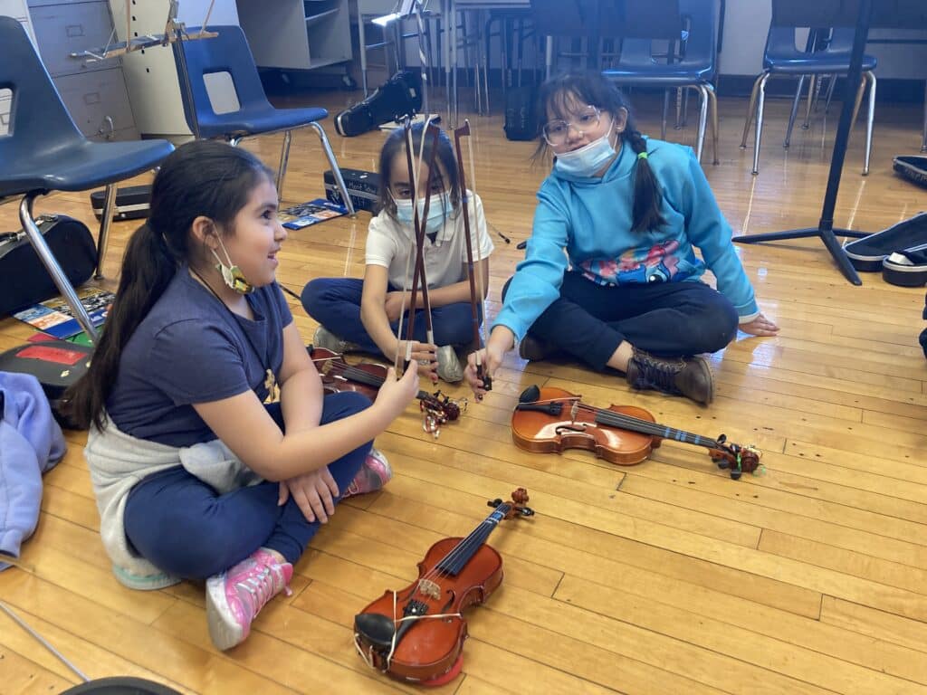 young strings players comparing bows