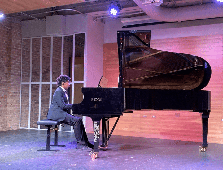 A student plays piano onstage.