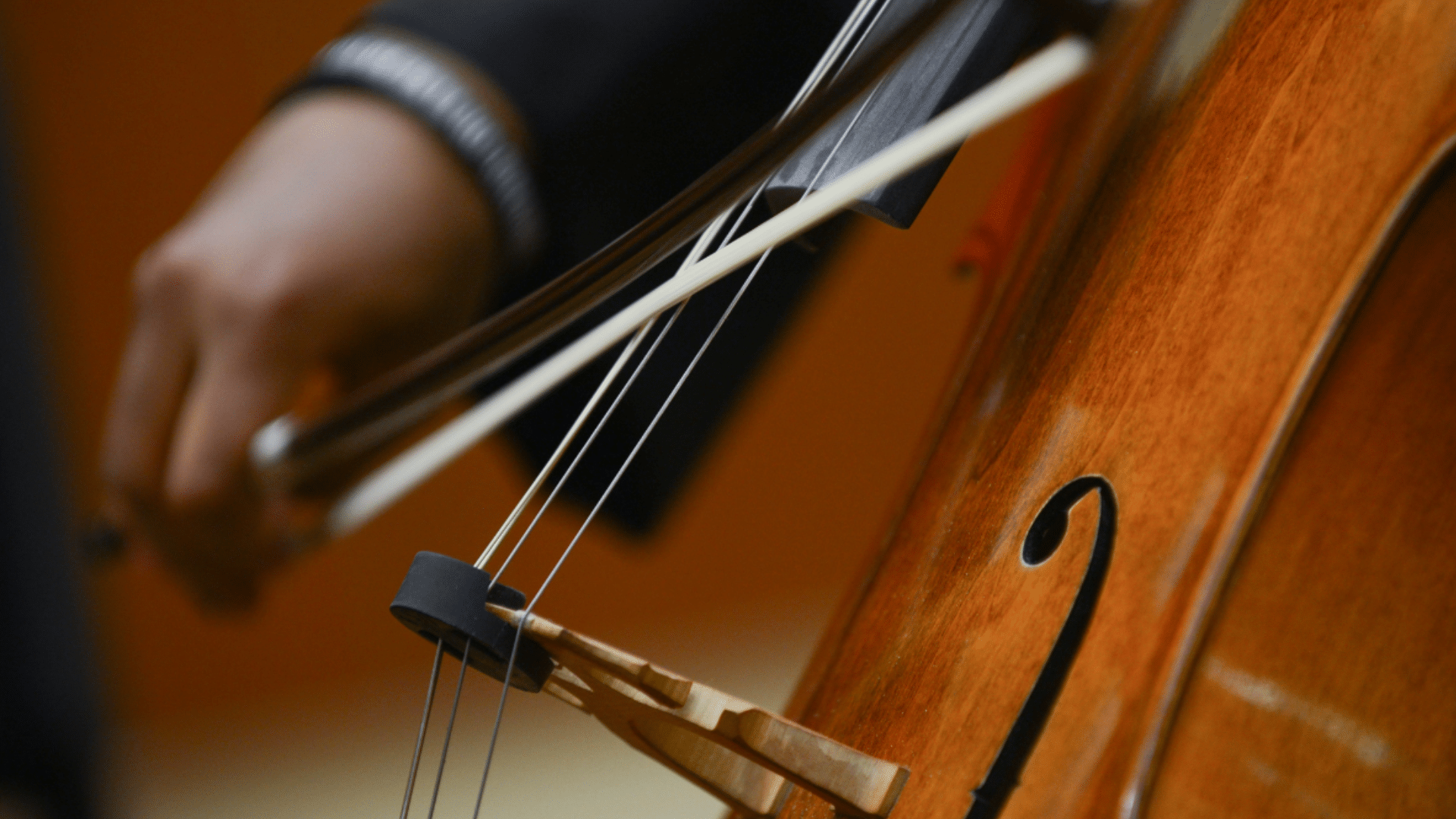 A close up shot of a cello being played.