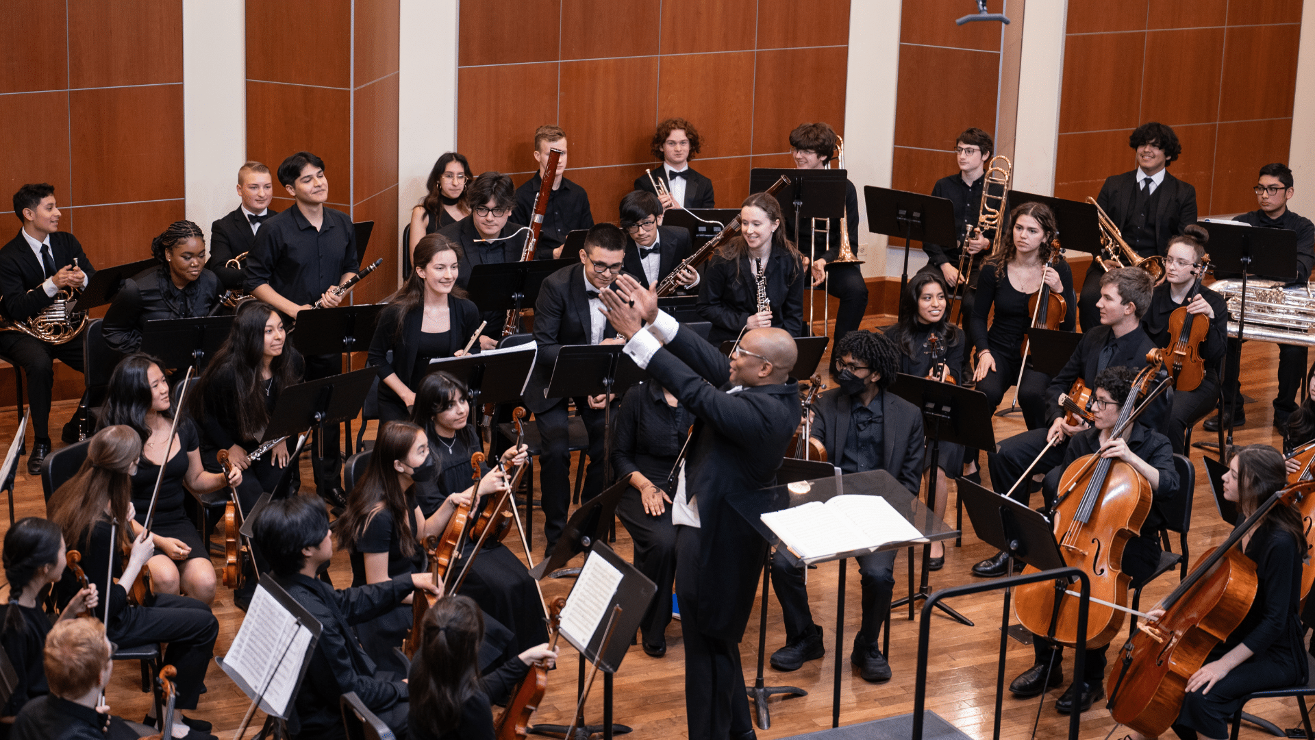 Merit Philharmonic plays onstage, with Steven Gooden conducting.