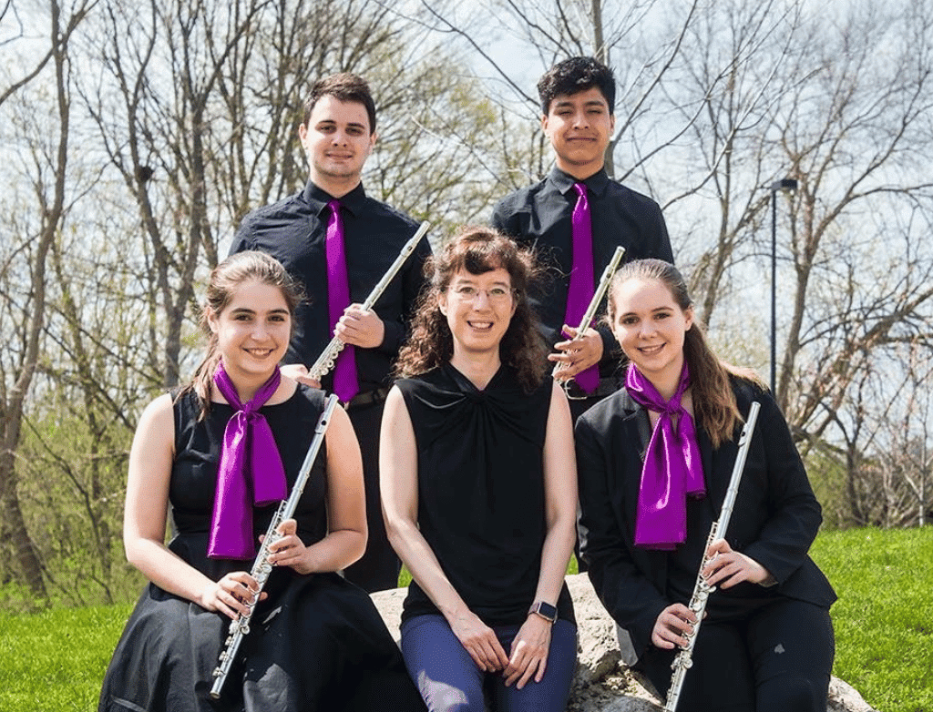 The Purple Hippopotami pose with coach Betsy Ko outdoors at the M-Prize Chamber Competition in 2018.