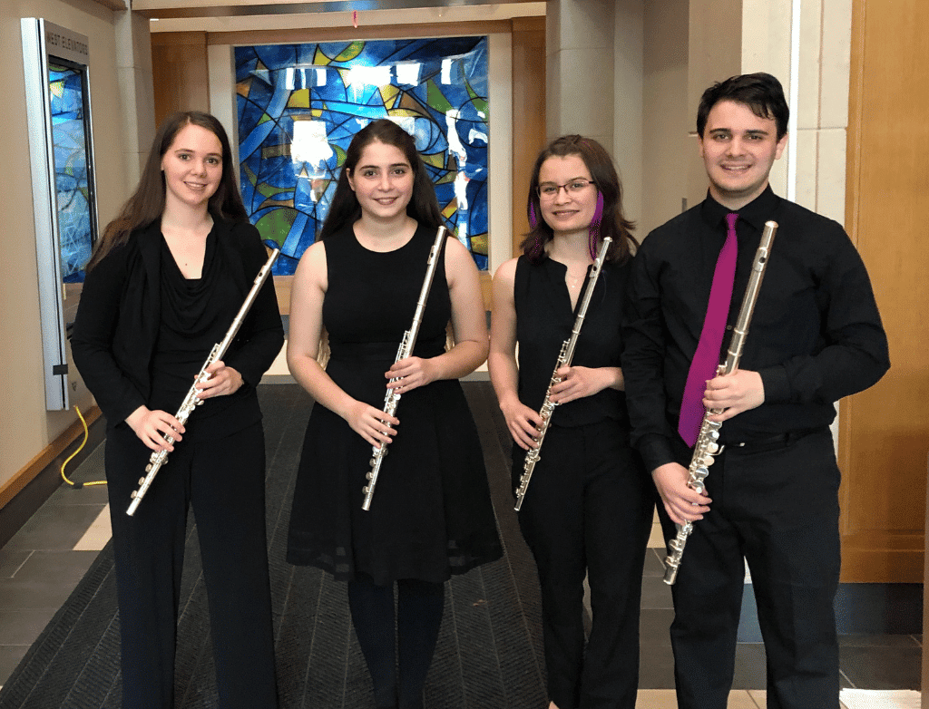 The 2018-2019 Purple Hippopotami pose with their flutes.