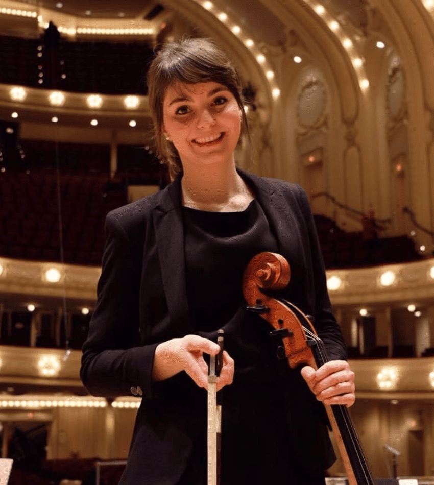 Eva Maria Barbado Gutierrez holding a cello onstage.