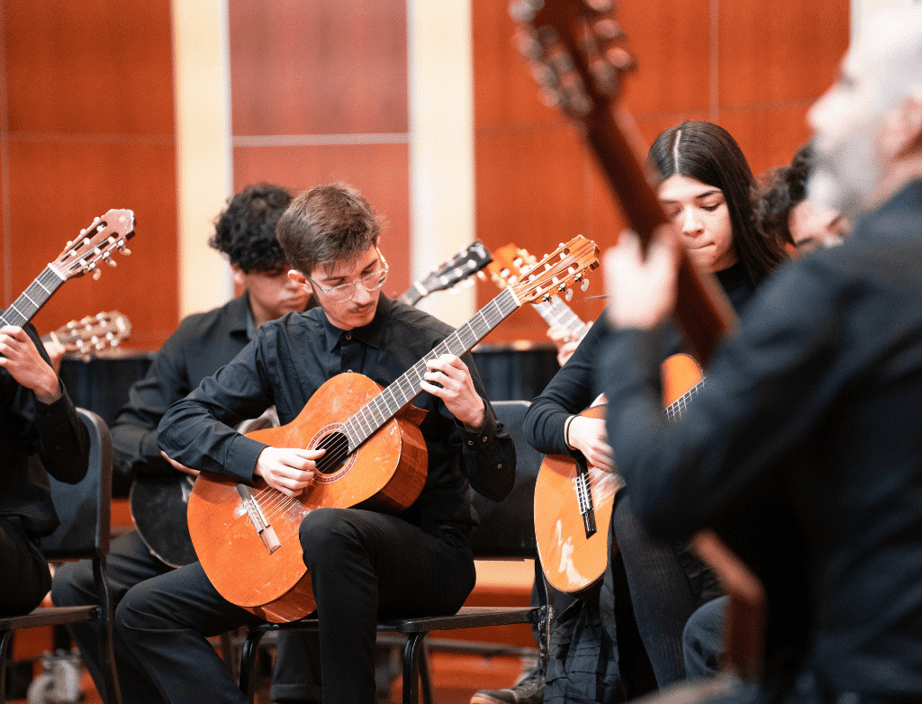 The Guitar Ensemble performs onstage.