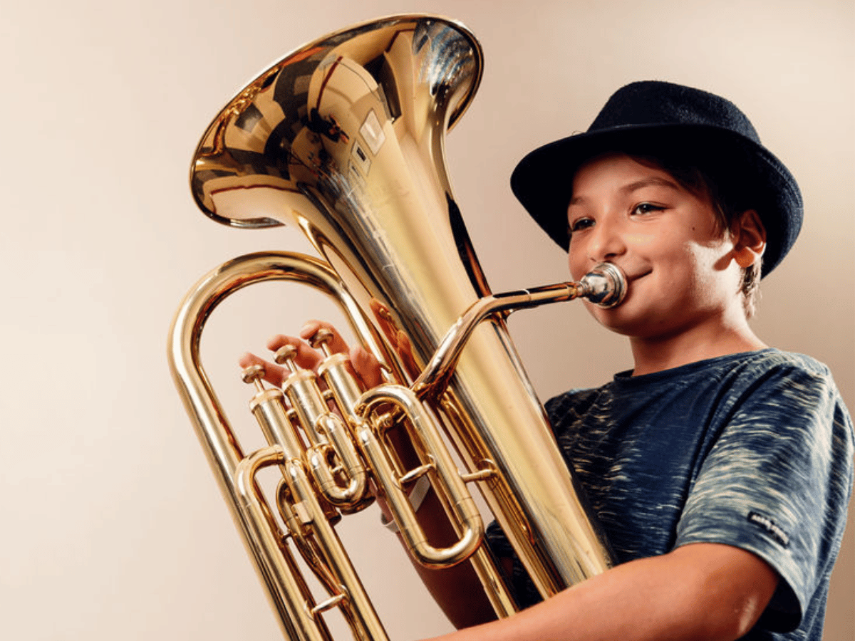 A student in a hat plays euphonium.