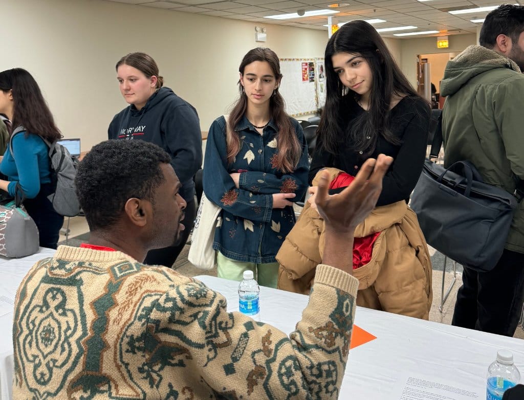 A man gestures and talks to a group of students