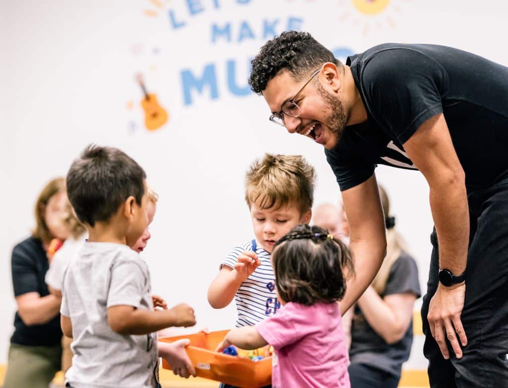A teacher with several toddlers picking out toys