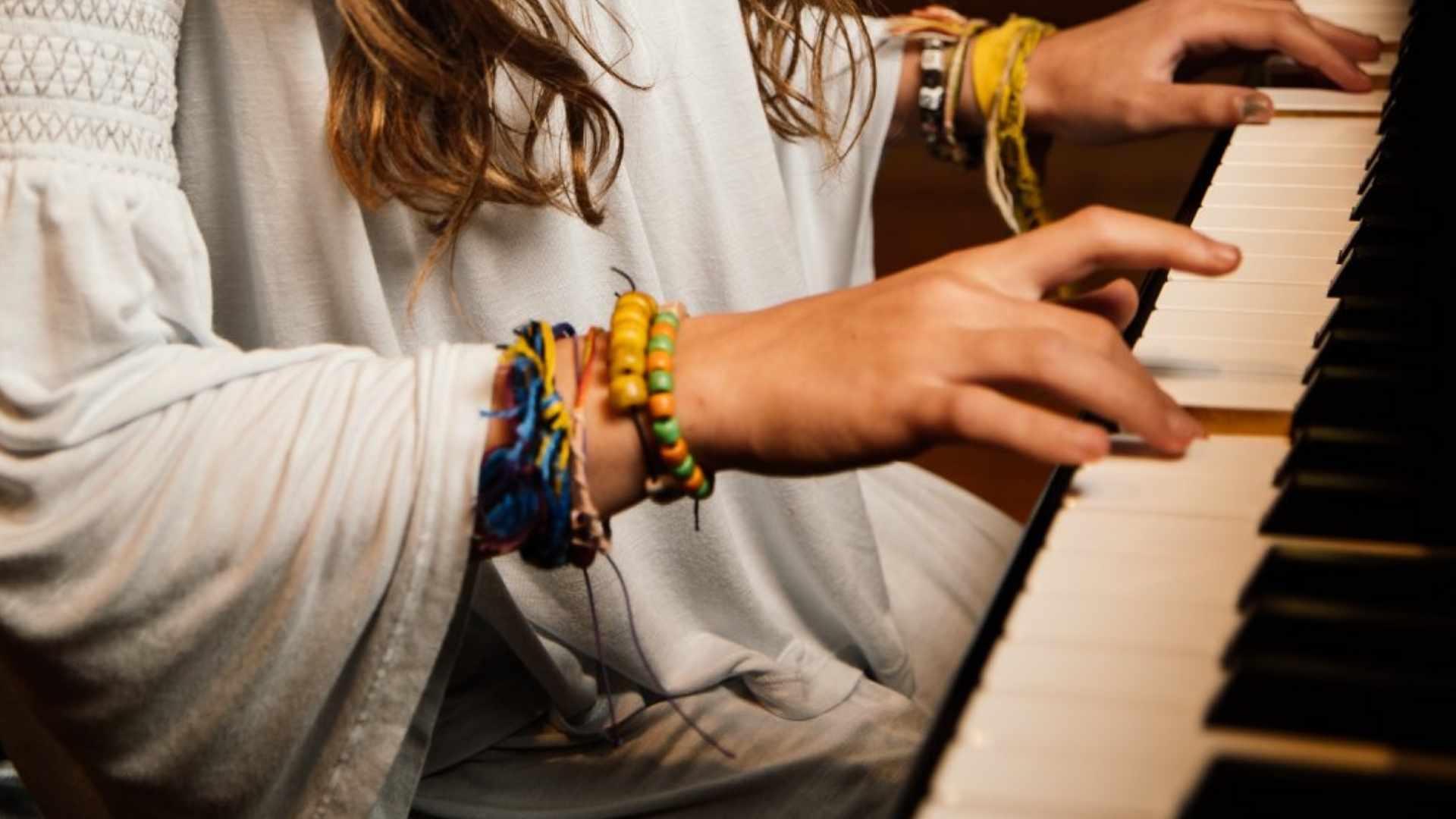 A closeup of a child's hands on a piano