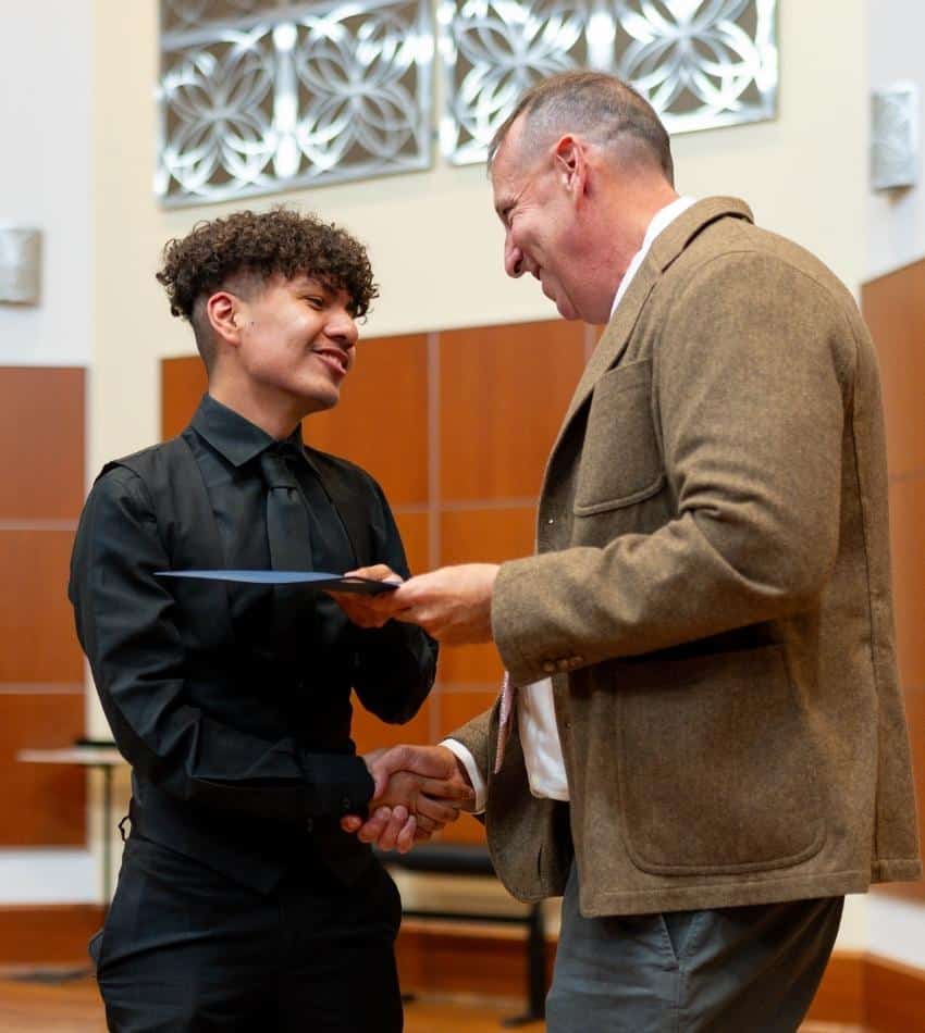 Dr. Abarbanell shakes hands with a student.